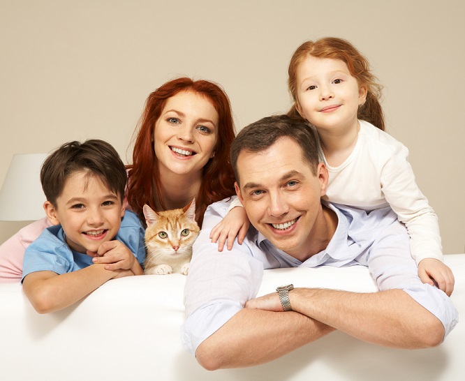 Portrait of siblings and their parents with cute cat looking at camera