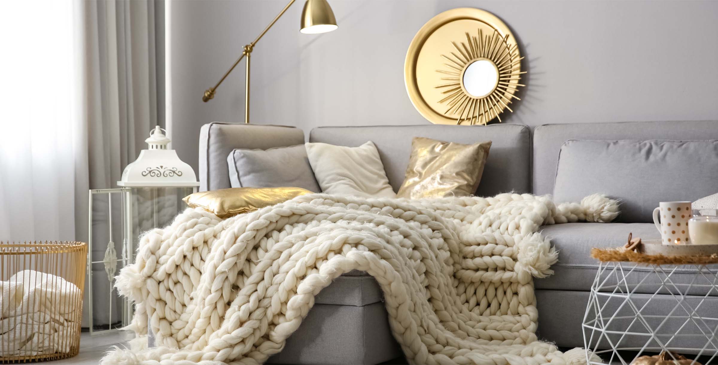 Cozy bedroom interior with a neatly made bed, layered blankets, neutral decor, and soft natural light creating a warm, comfortable atmosphere.